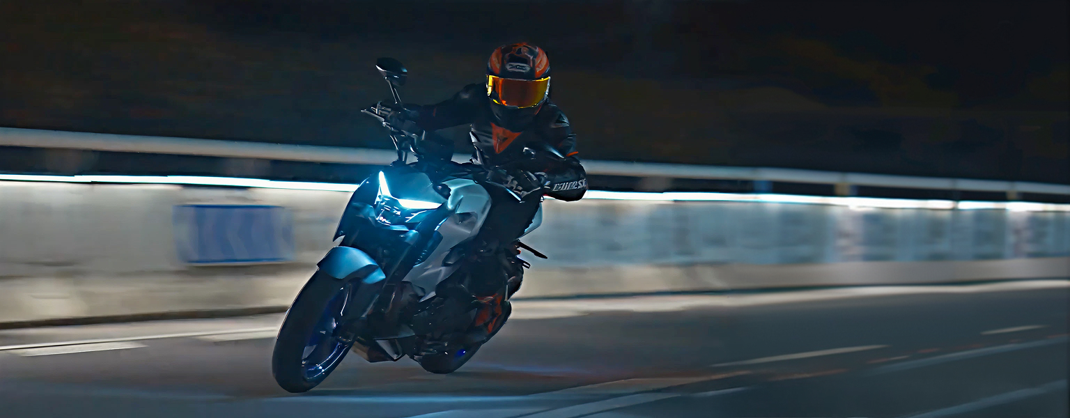 Zontes motos en Uruguay - Rider con Zontes 350R gris inclinando de noche sobre asfalto mojado.