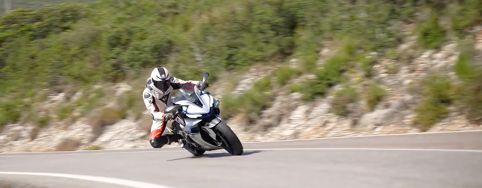 Zontes motos en Uruguay - Zontes 703RR inclinando en curva sobre la ruta con piloto equipado y una postura agresiva de manejo deportivo.