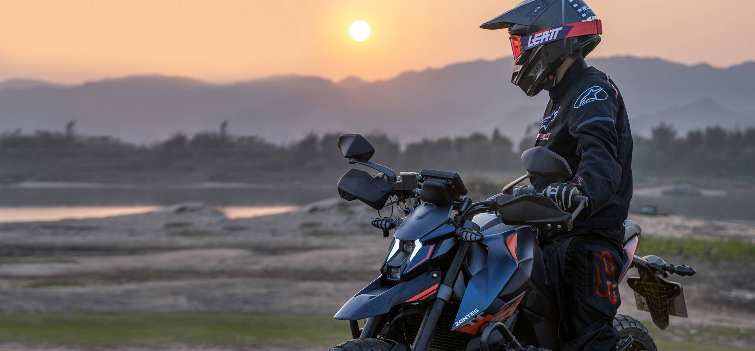Zontes motos en Uruguay - Zontes 200U detenida con conductor equipado frente a un paisaje abierto al atardecer.