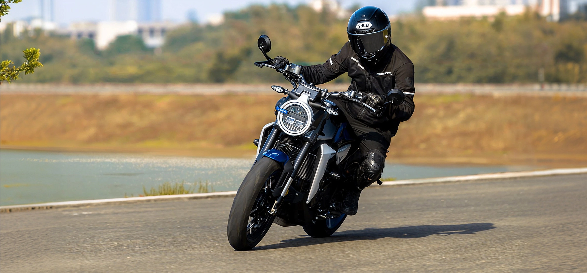 Zontes motos en Uruguay - Moto Zontes 350GK circulando en curva con piloto de casco integral y postura deportiva. Zontes motos en Uruguay - Zontes 350GK en marcha sobre asfalto con conductor equipado y moto inclinada en curva.