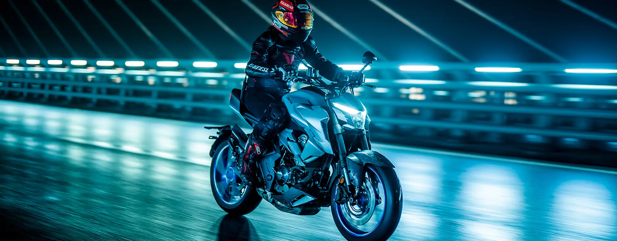 Zontes motos en Uruguay - Zontes 350R blanca en accion nocturna. Zontes motos en Uruguay - Rider con Zontes 350R blanca rodando de noche sobre asfalto mojado.