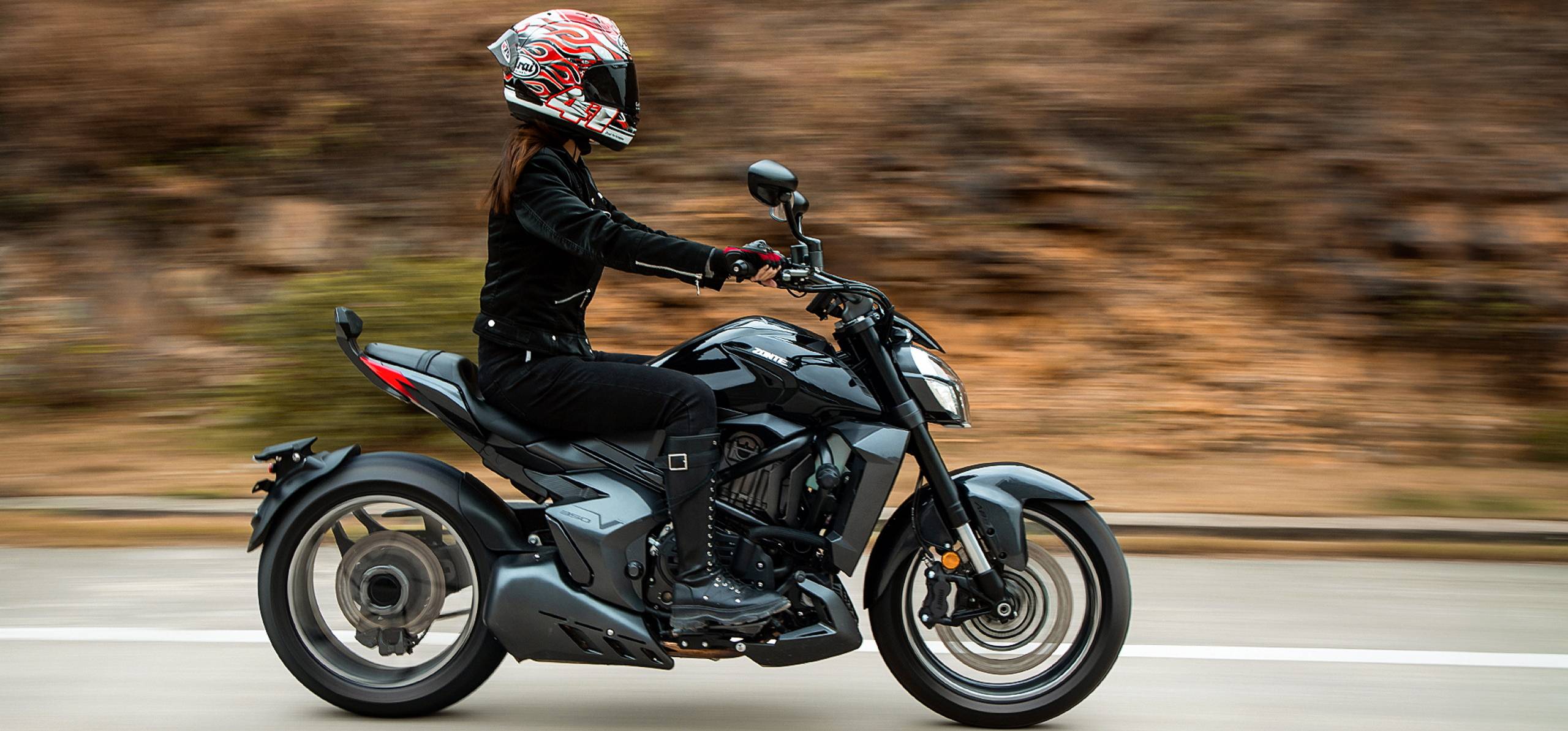 Zontes motos en Uruguay - Zontes 350V en movimiento con perfil alargado, postura relajada y un conjunto de lineas modernas. Zontes motos en Uruguay - Zontes 350V negra en desplazamiento lateral con piloto equipado con casco integral y vestimenta oscura.