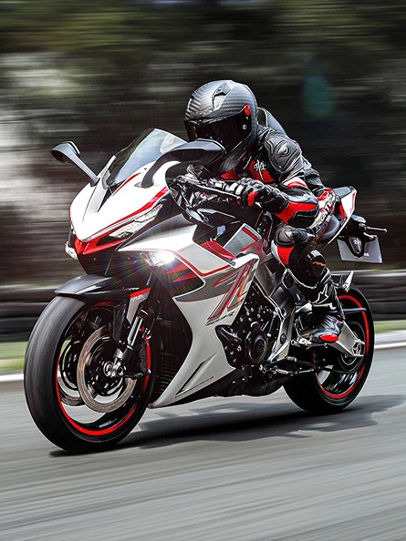 Zontes motos en Uruguay - Zontes 703RR en marcha con conductor agachado, faro encendido y carenado blanco con detalles rojos.