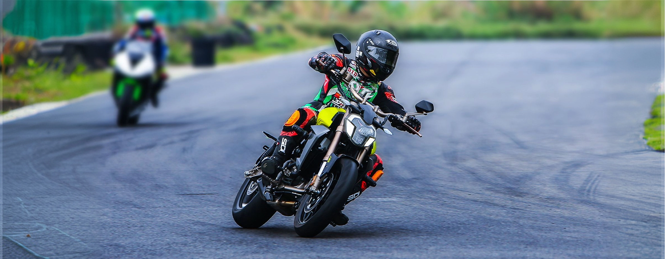 Zontes motos en Uruguay - Zontes 310V amarilla en pista con piloto inclinado en curva y otra moto al fondo.
