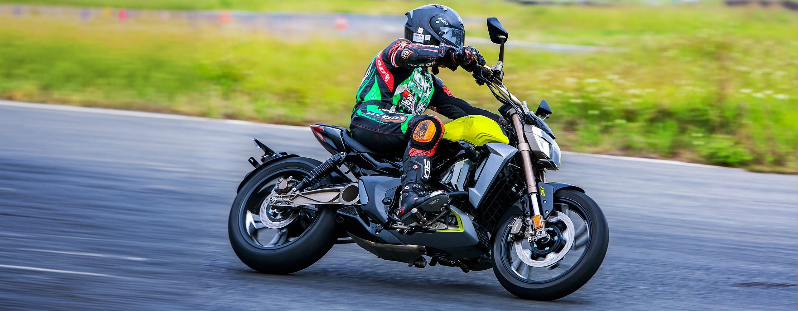 Zontes motos en Uruguay - Moto Zontes 310V amarilla en movimiento lateral con piloto inclinado sobre una pista asfaltada.