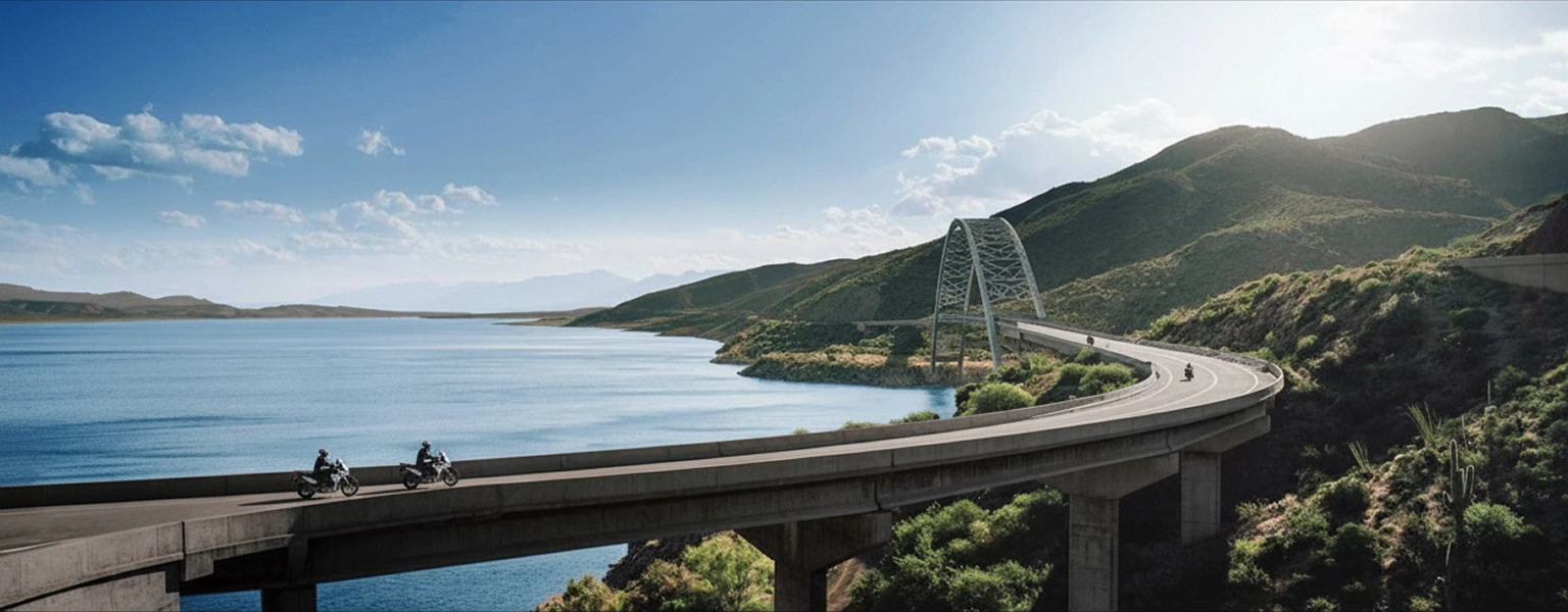 Zontes motos en Uruguay - Ruta sobre un lago con varias motos circulando junto a montañas y un puente curvo.