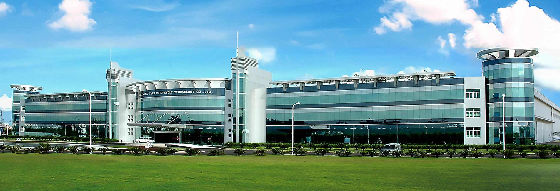 Zontes motos en Uruguay - Edificio corporativo de gran tamaño con fachada vidriada, jardines y cielo despejado.